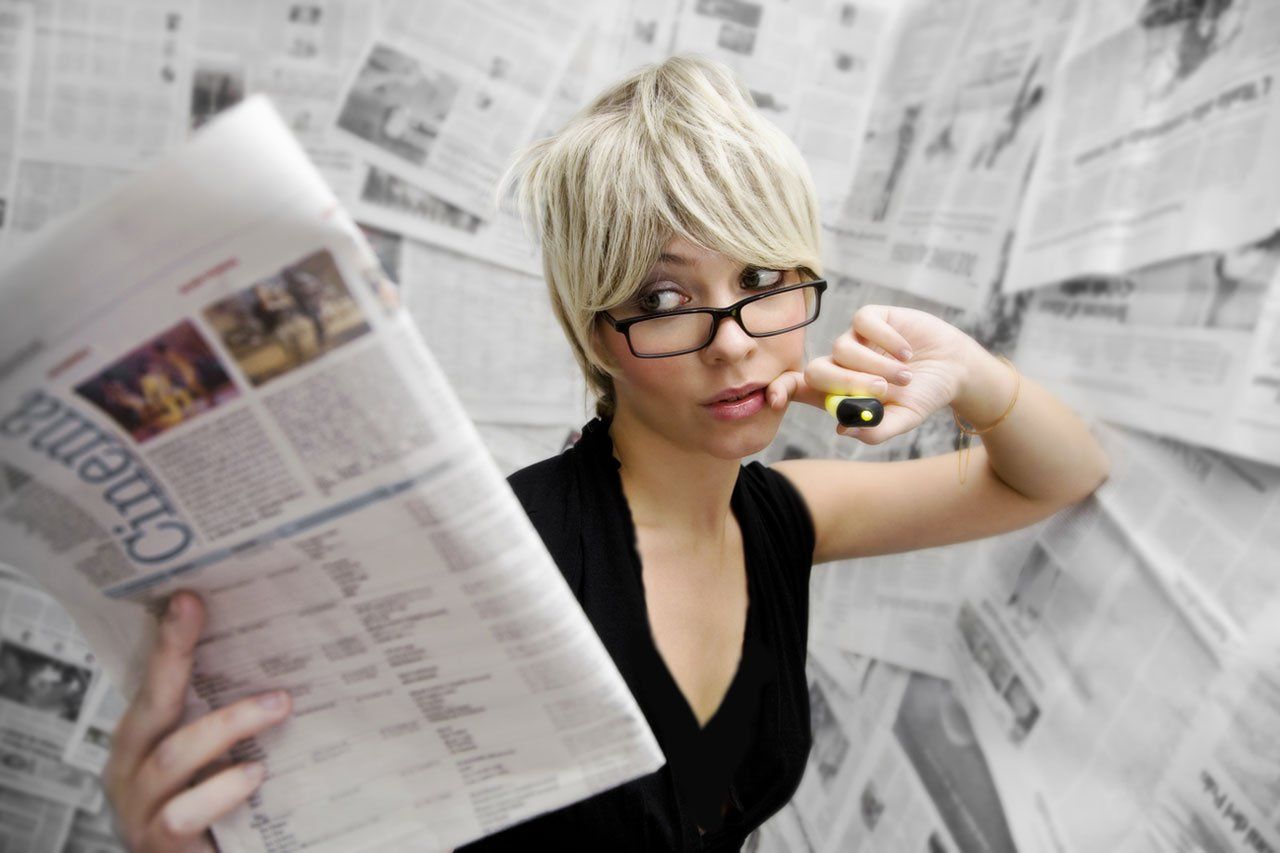 A woman is reading a newspaper