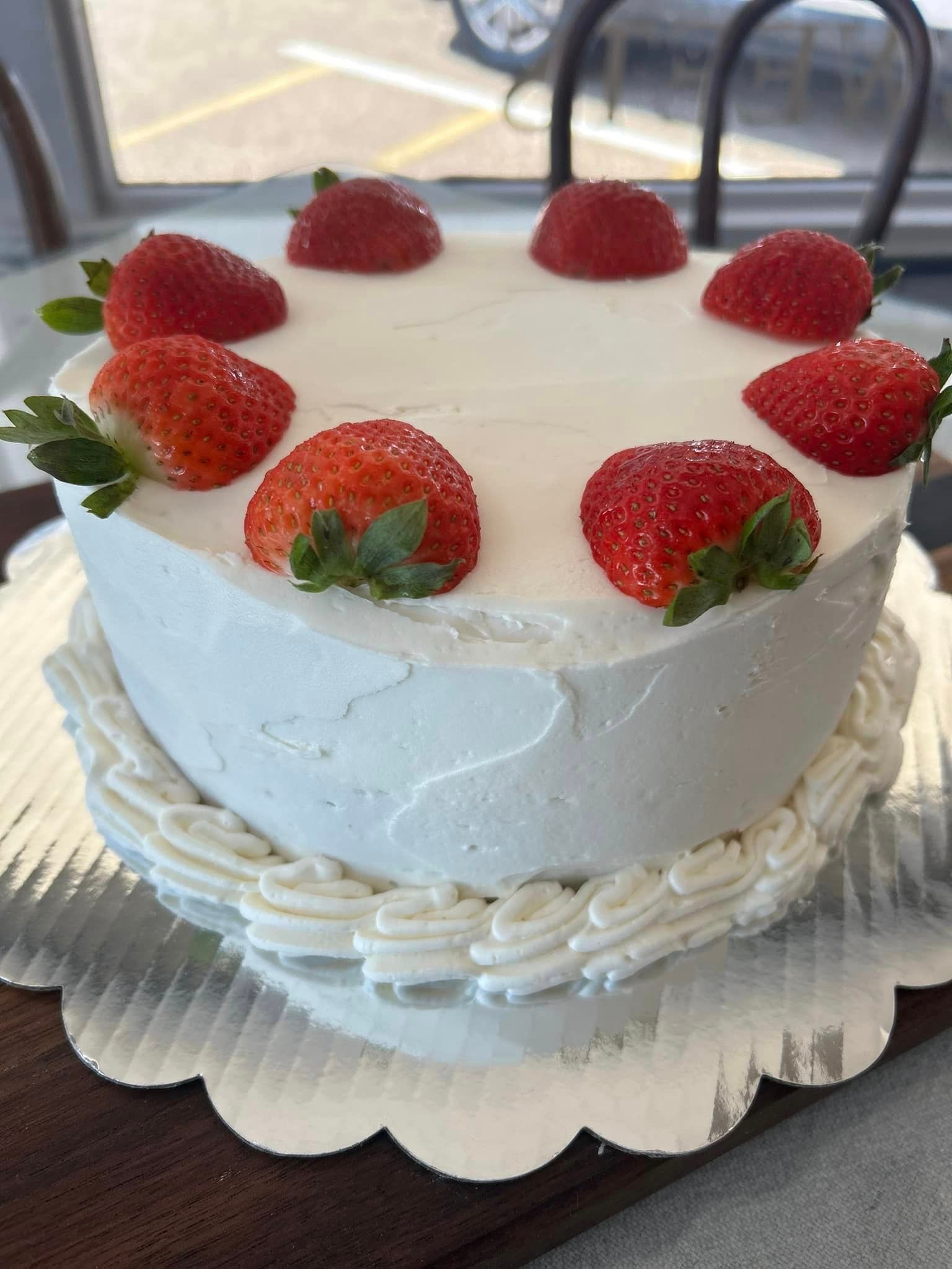 A cake with strawberries on top of it on a table.