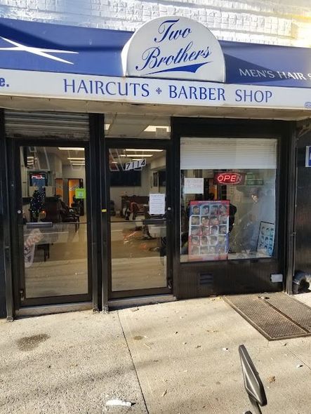 Exterior of Two Brothers Haircuts and Barber Shop with signage and glass doors.