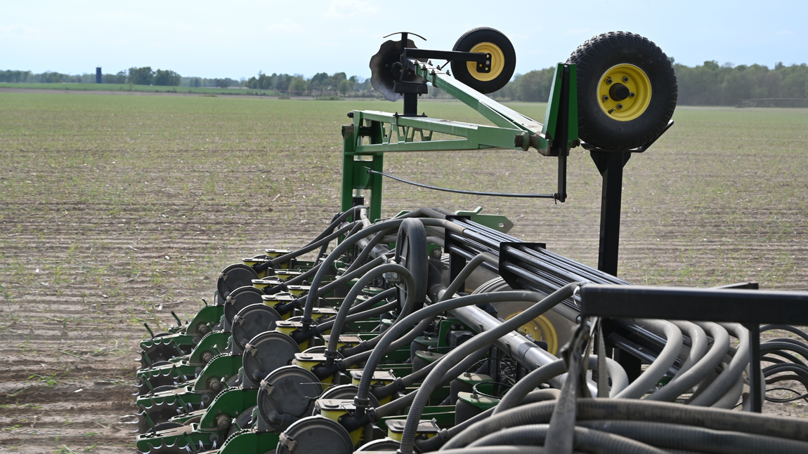 A john deere tractor is sitting in the middle of a field.
