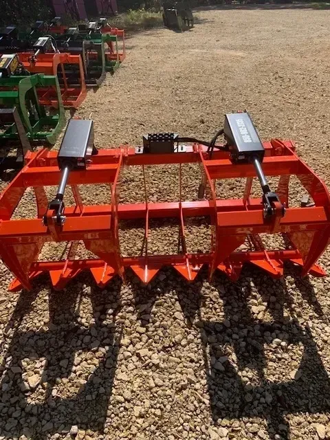 A large orange machine is sitting on top of a gravel road.