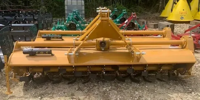 A large yellow machine is sitting on top of a dirt field.