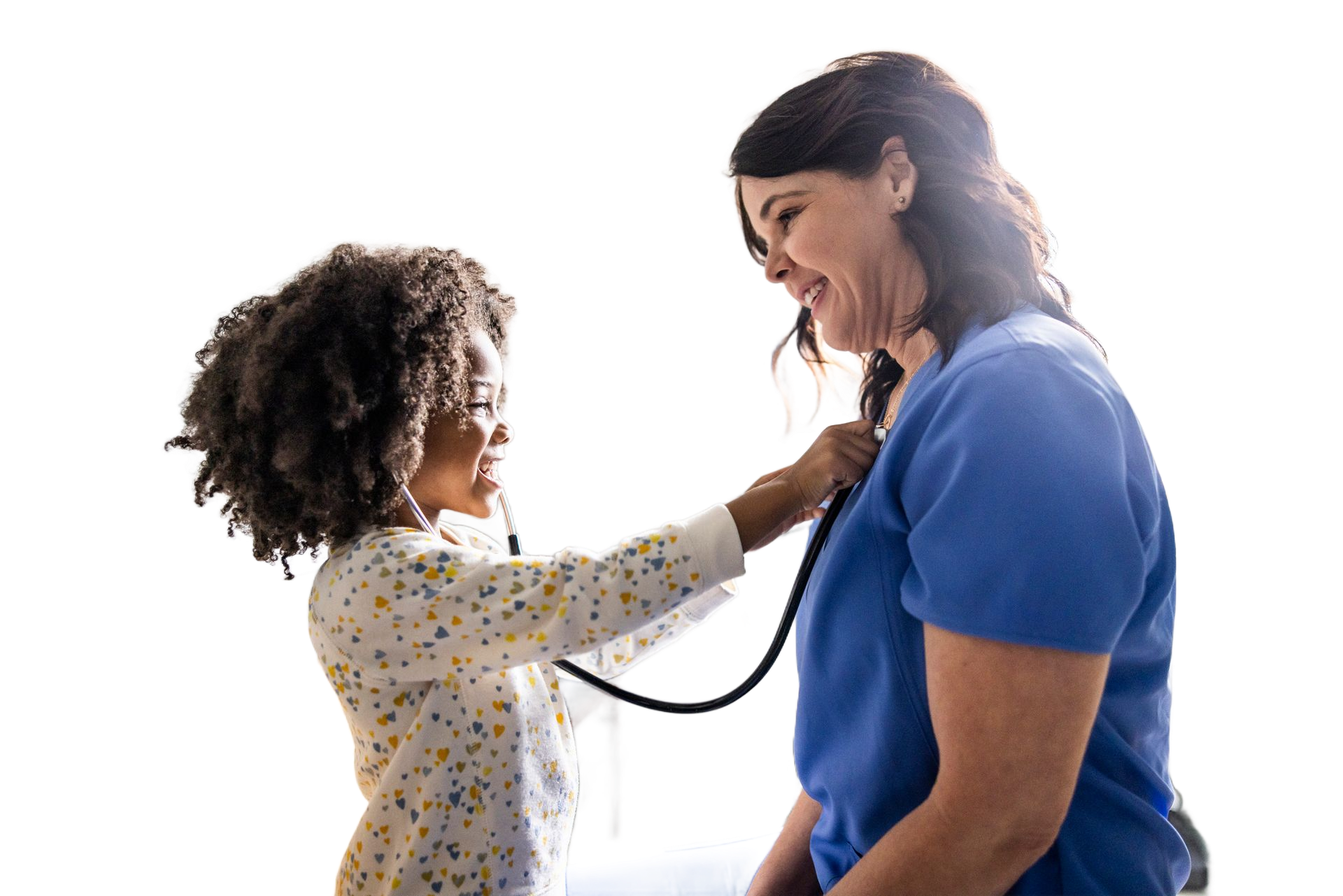 A young girl using a stethoscope on a smiling woman in blue scrubs.