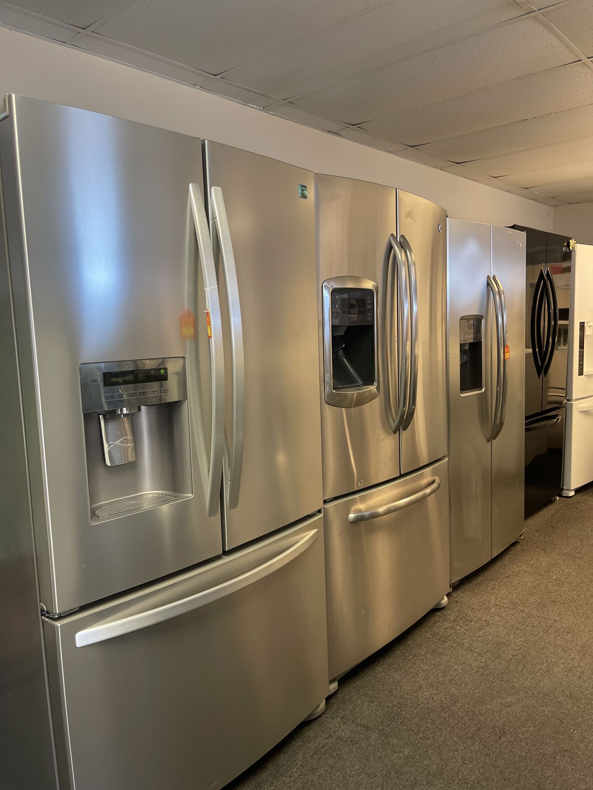 A row of stainless steel refrigerators in a store