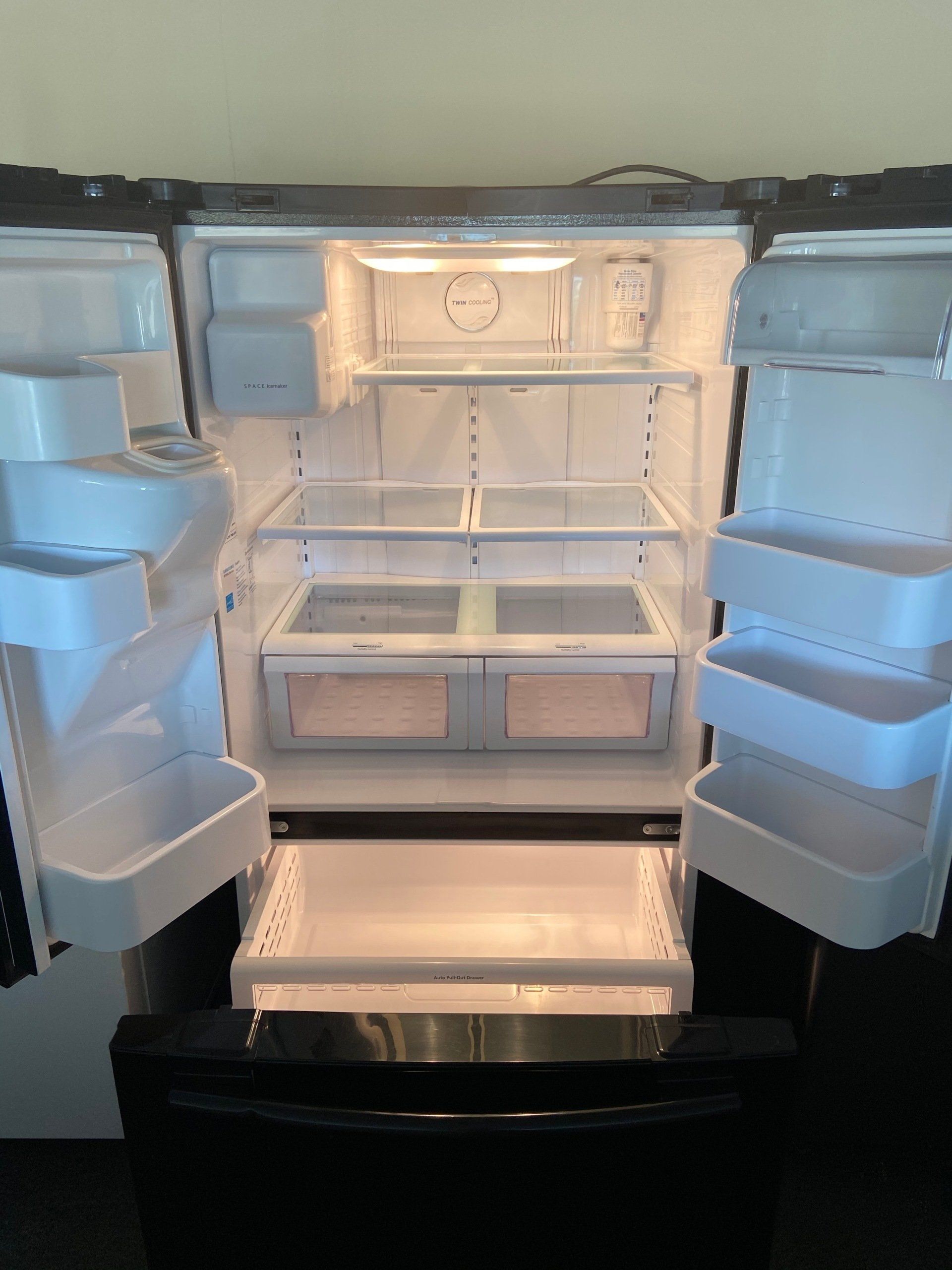 The inside of an empty refrigerator with the door open.