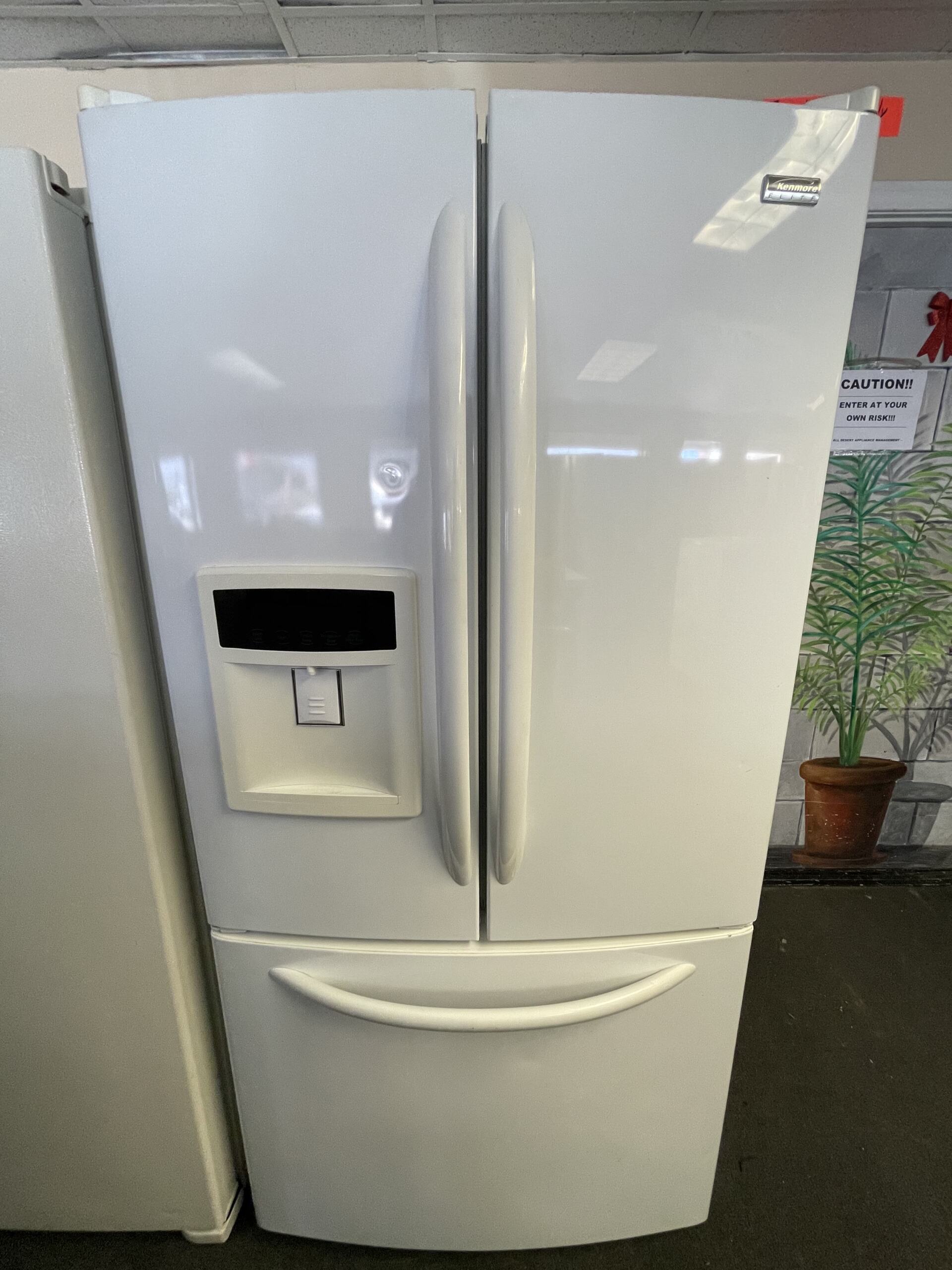 A white refrigerator with a water dispenser on the door.