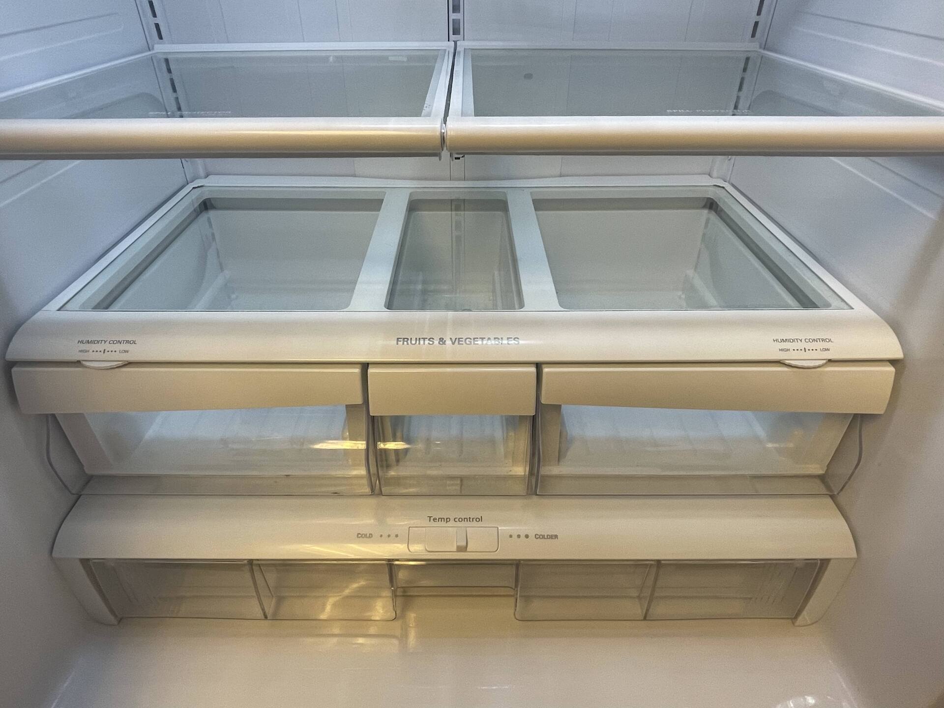 The inside of an empty refrigerator with a glass door