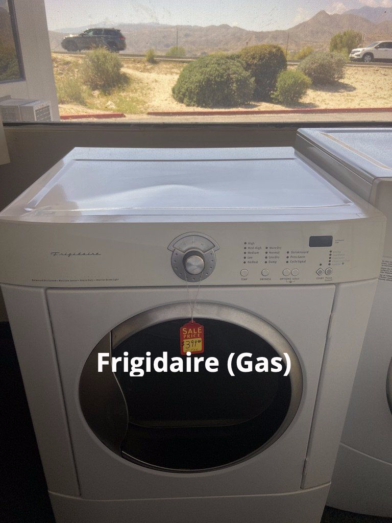 A frigidaire gas dryer is sitting in front of a window