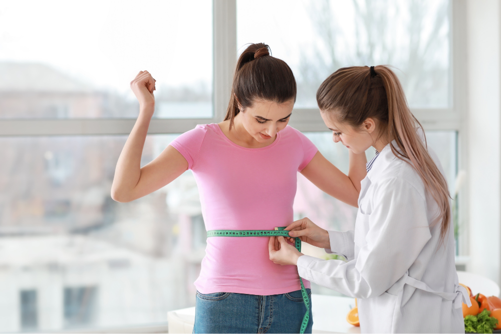 A woman is being measured by a doctor with a tape measure.