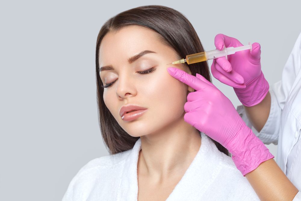 A woman is getting a botox injection in her face.