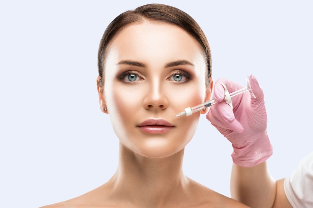 A woman is getting a botox injection in her face.