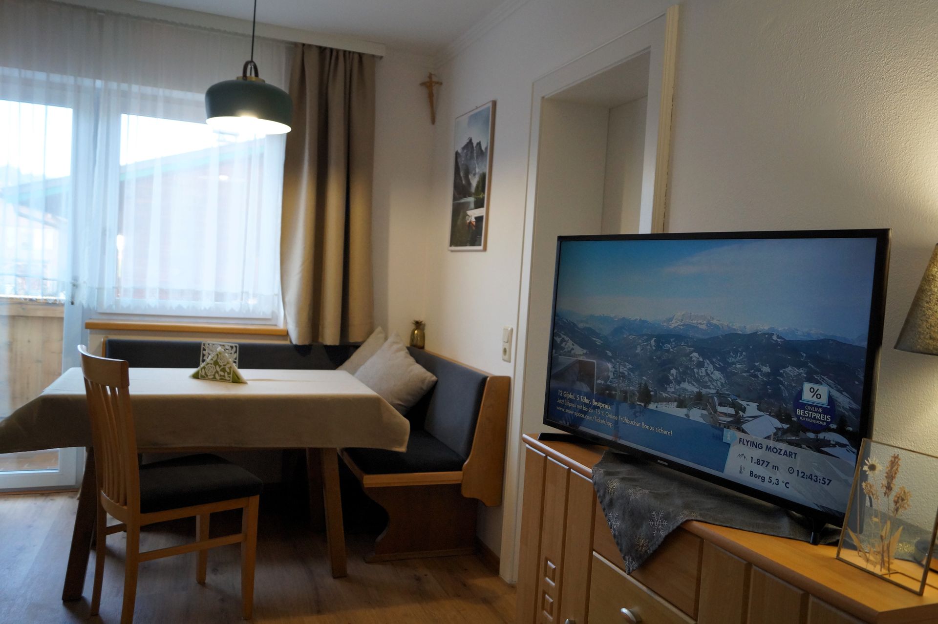 Ein Wohnzimmer mit Tisch und Stühlen und einem Flachbildfernseher