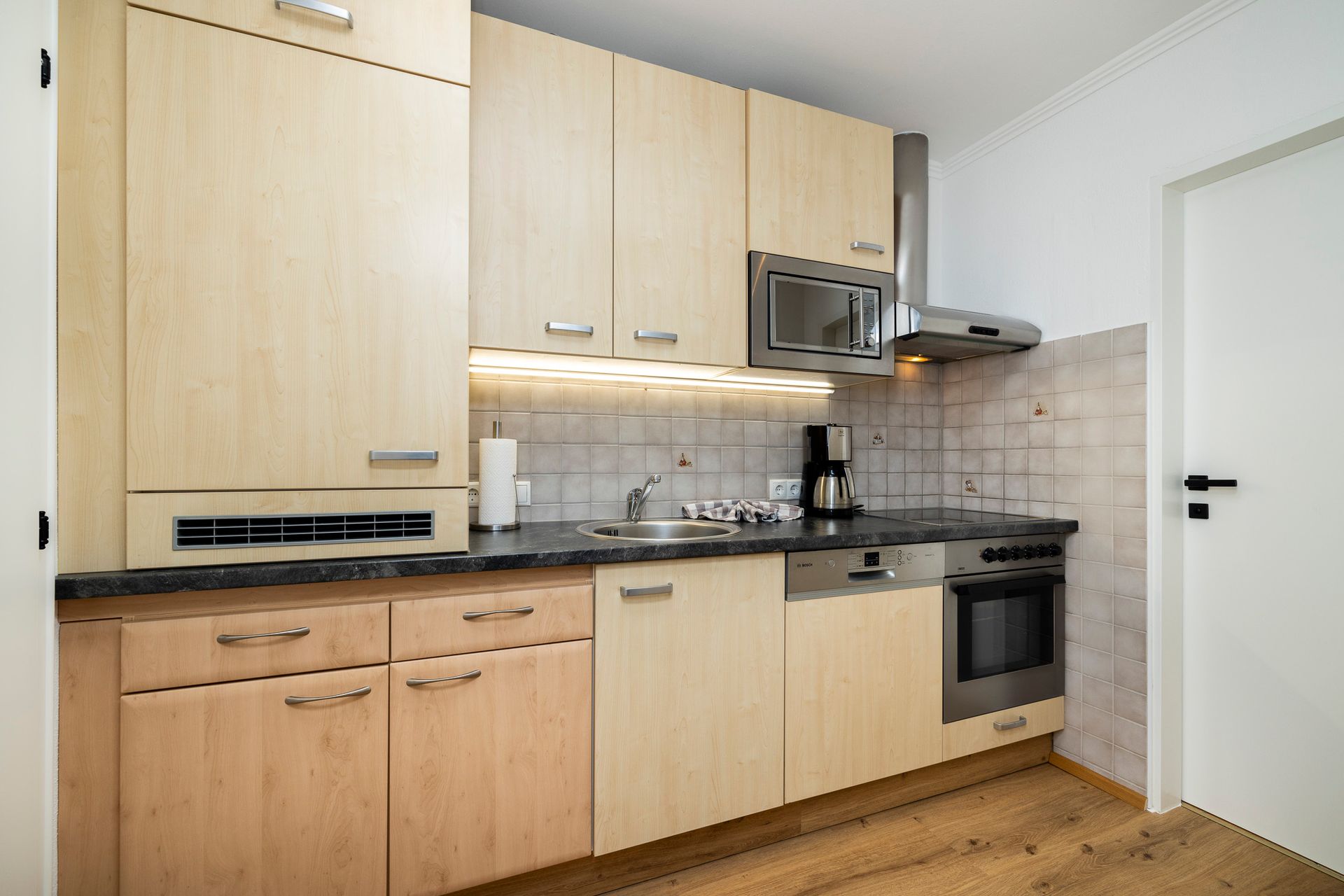 Eine Küche mit Holzschränken und Geräten aus Edelstahl