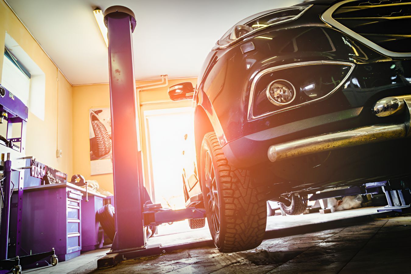 A Car is Sitting on a Lift in a Garage — K & T Ballina Mechanical In Ballina, NSW