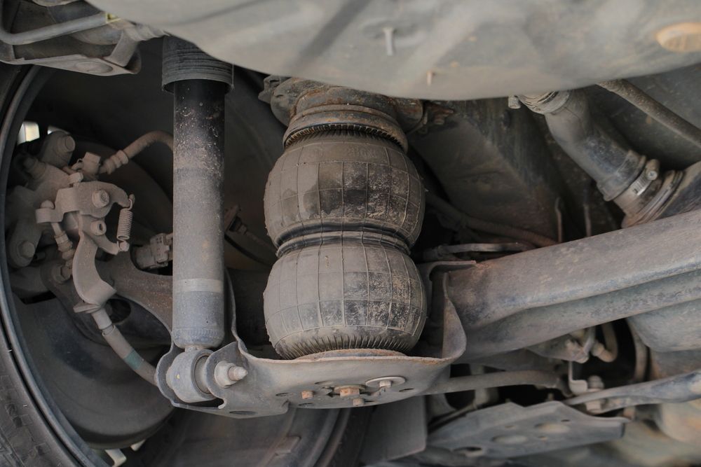 Undercarriage View Showing a Black Air Suspension Bag Between the Car's Frame and Axle — K & T Ballina Mechanical In Ballina, NSW