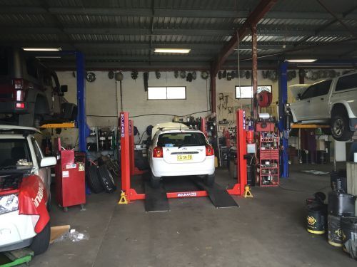 A Man is Working on a Car in a Garage — K & T Ballina Mechanical In Ballina, NSW