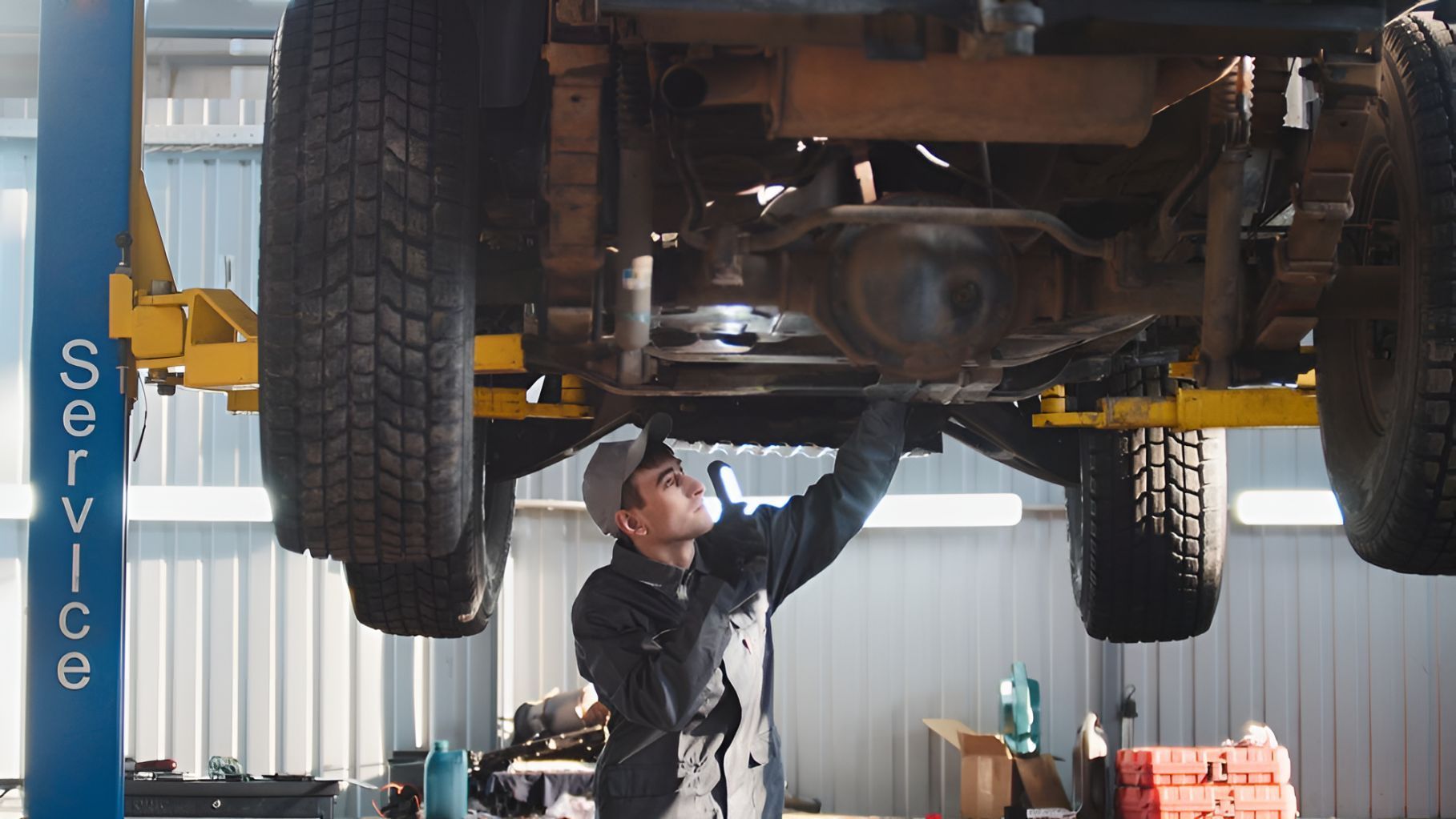 A Man is Working Under a Truck on a Lift in a Garage — K & T Ballina Mechanical In Ballina, NSW