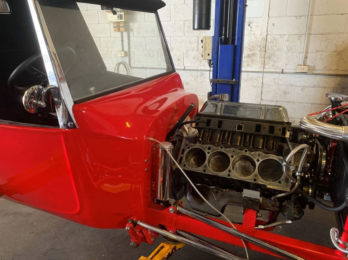 A Red Car With the Engine Removed is Sitting on a Lift — K & T Ballina Mechanical In Ballina, NSW
