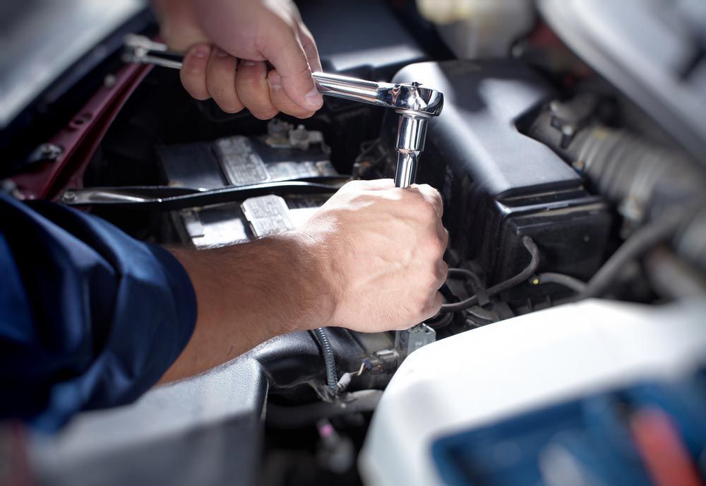 A Man is Working on a Car Engine With a Wrench — K & T Ballina Mechanical In Ballina, NSW