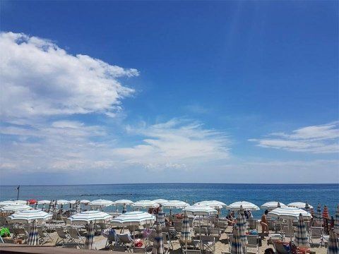 Breiter Strand mit Sonnenschirmen und Liegen