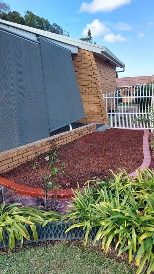Brick House With Large Grey Shades — Brett Continuous Concrete Kerbing & Edging In Laurieton, NSW