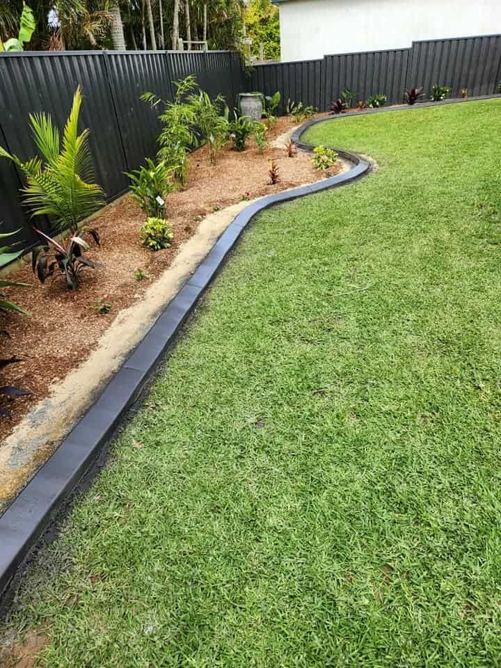 Curved Garden Bed Bordered by a Black Edging — Brett Continuous Concrete Kerbing & Edging In Bonny Hills, NSW