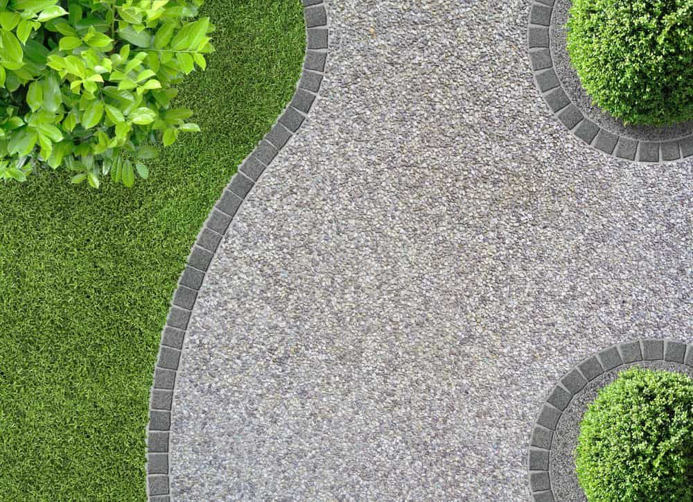Curved Gravel Path Bordered by Smooth Grey Stones — Brett Continuous Concrete Kerbing & Edging In Bonny Hills, NSW