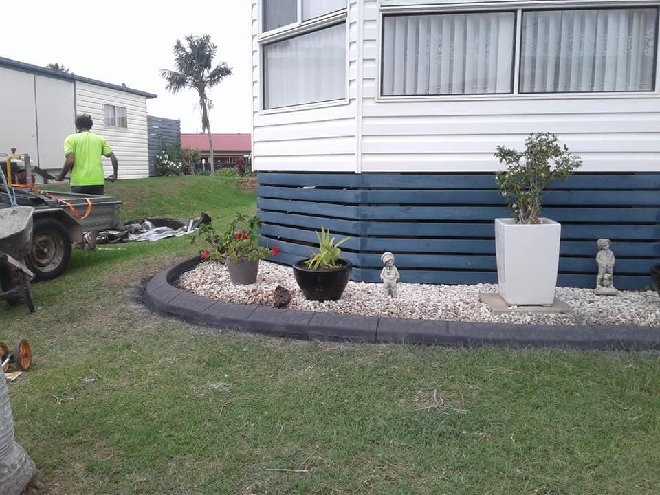 A Landscaped Garden With Potted Plants and Small Statues — Brett Continuous Concrete Kerbing & Edging In Lake Cathie, NSW