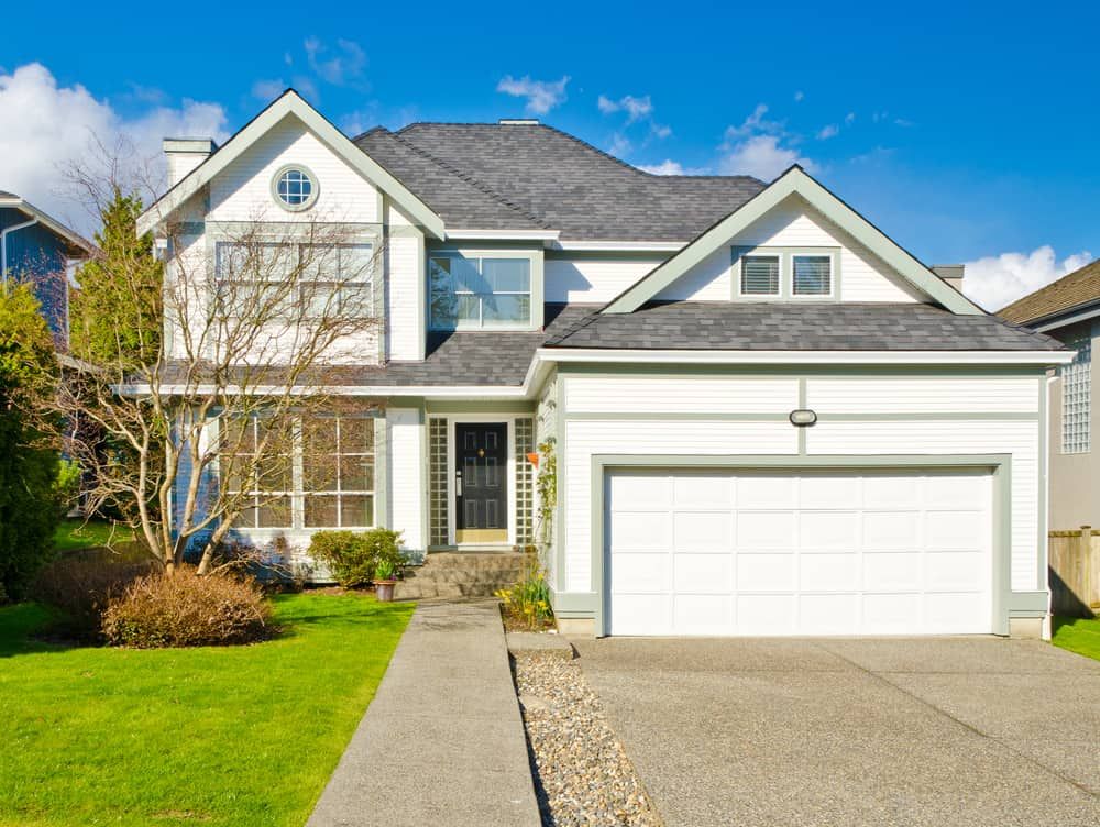 Two-storey White House With Dark Roof and Large Windows — Brett Continuous Concrete Kerbing & Edging In Bonny Hills, NSW
