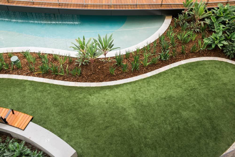Curved Garden Design Featuring Lush Green Grass — Brett Continuous Concrete Kerbing & Edging In Lakewood, NSW