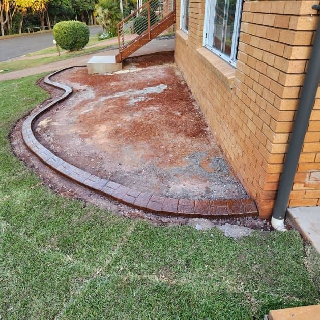 A Brick House With a Curved Sidewalk — Brett Continuous Concrete Kerbing & Edging In Lakewood, NSW