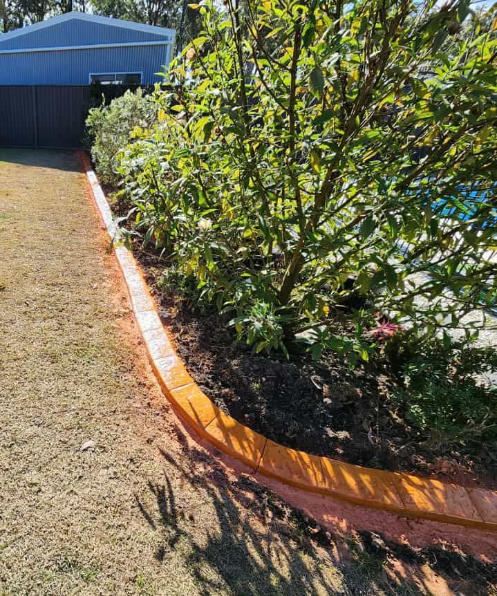 Curved Garden Bed With Orange Brick Border — Brett Continuous Concrete Kerbing & Edging In Lake Cathie, NSW