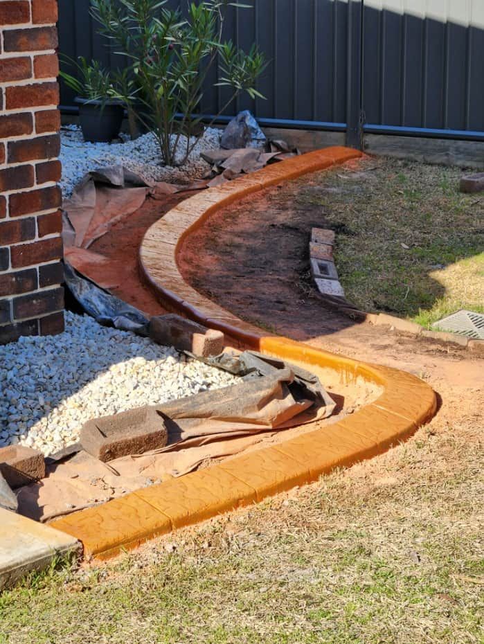 Curved Concrete Border Separates a Grassy Area — Brett Continuous Concrete Kerbing & Edging In Bonny Hills, NSW