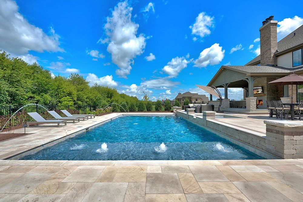 Big swimming pool with lounge chairs and water spray