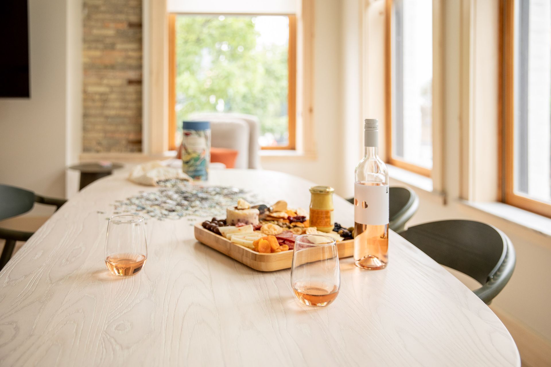 A table with a tray of food and a bottle of wine on it.
