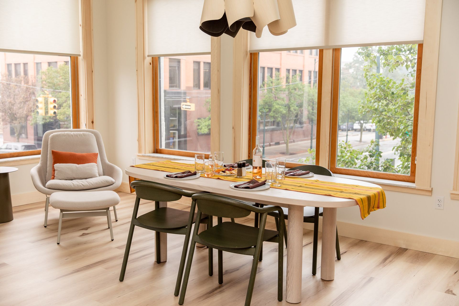 A dining room with a long table and chairs in front of a window.
