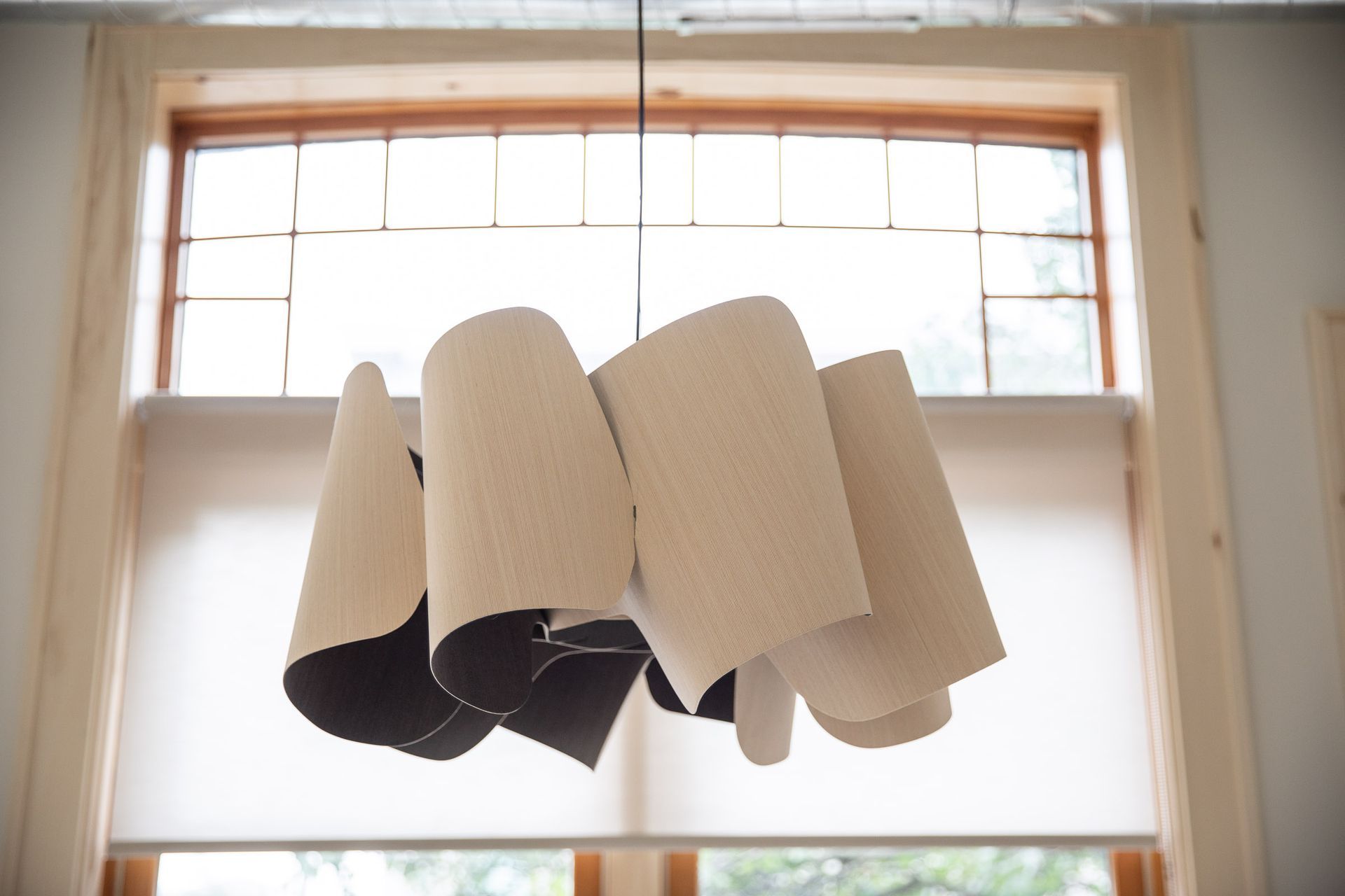 A lamp hanging from the ceiling in front of a window
