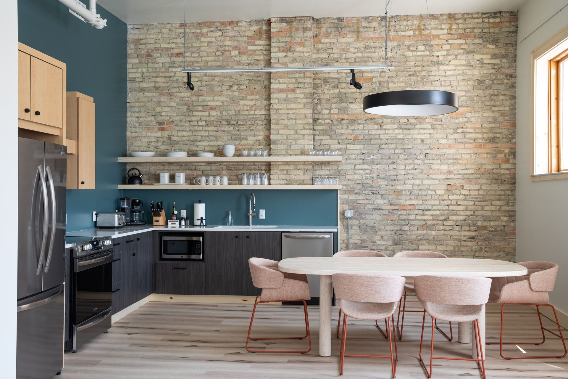A kitchen with a table and chairs and a brick wall.