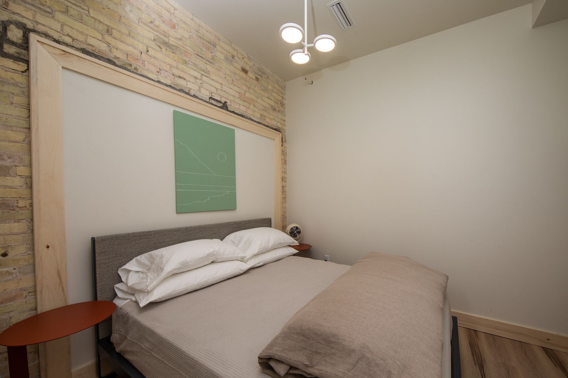 A bedroom with a large bed and a brick wall.