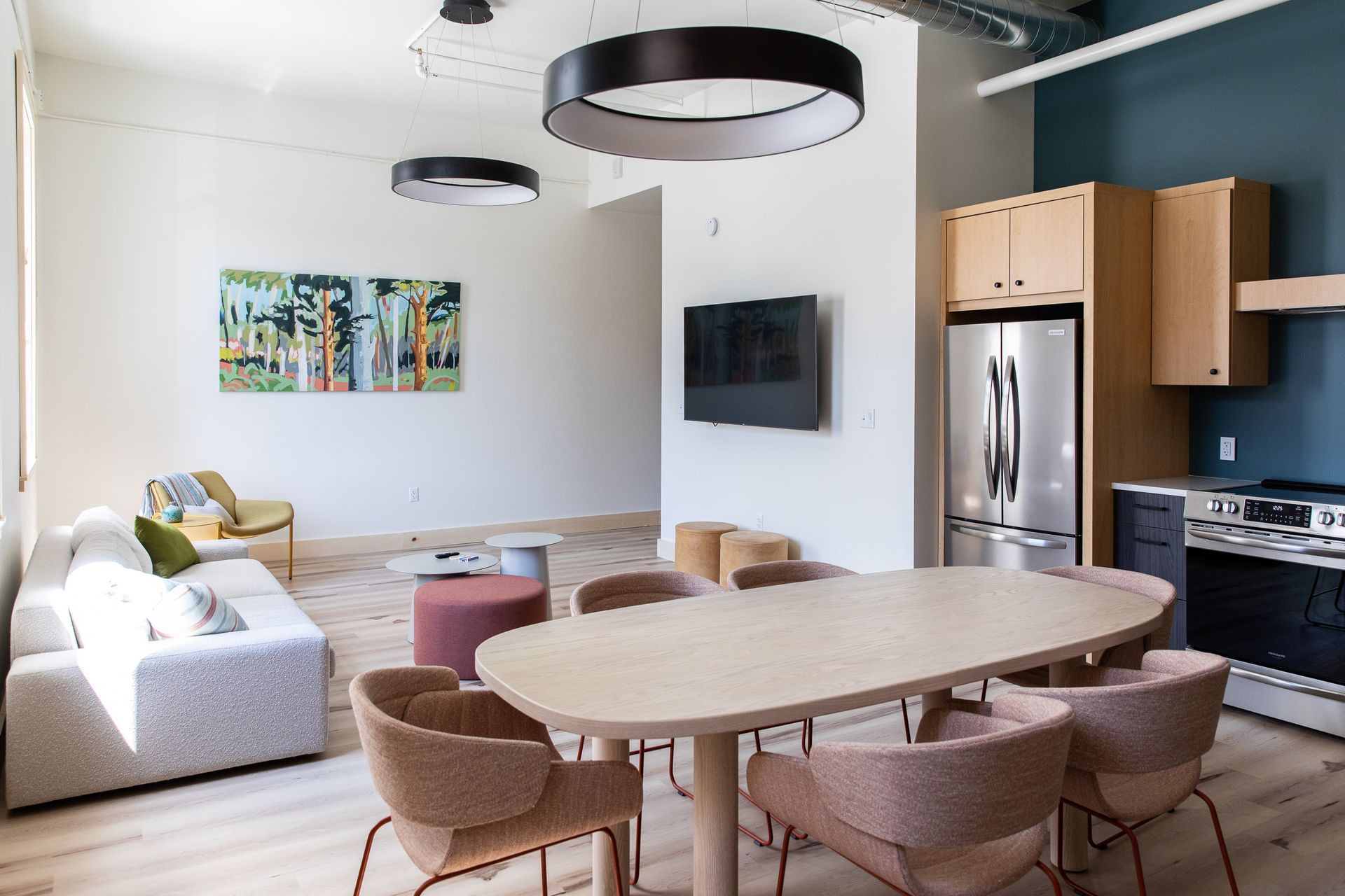 A living room with a table and chairs and a kitchen.
