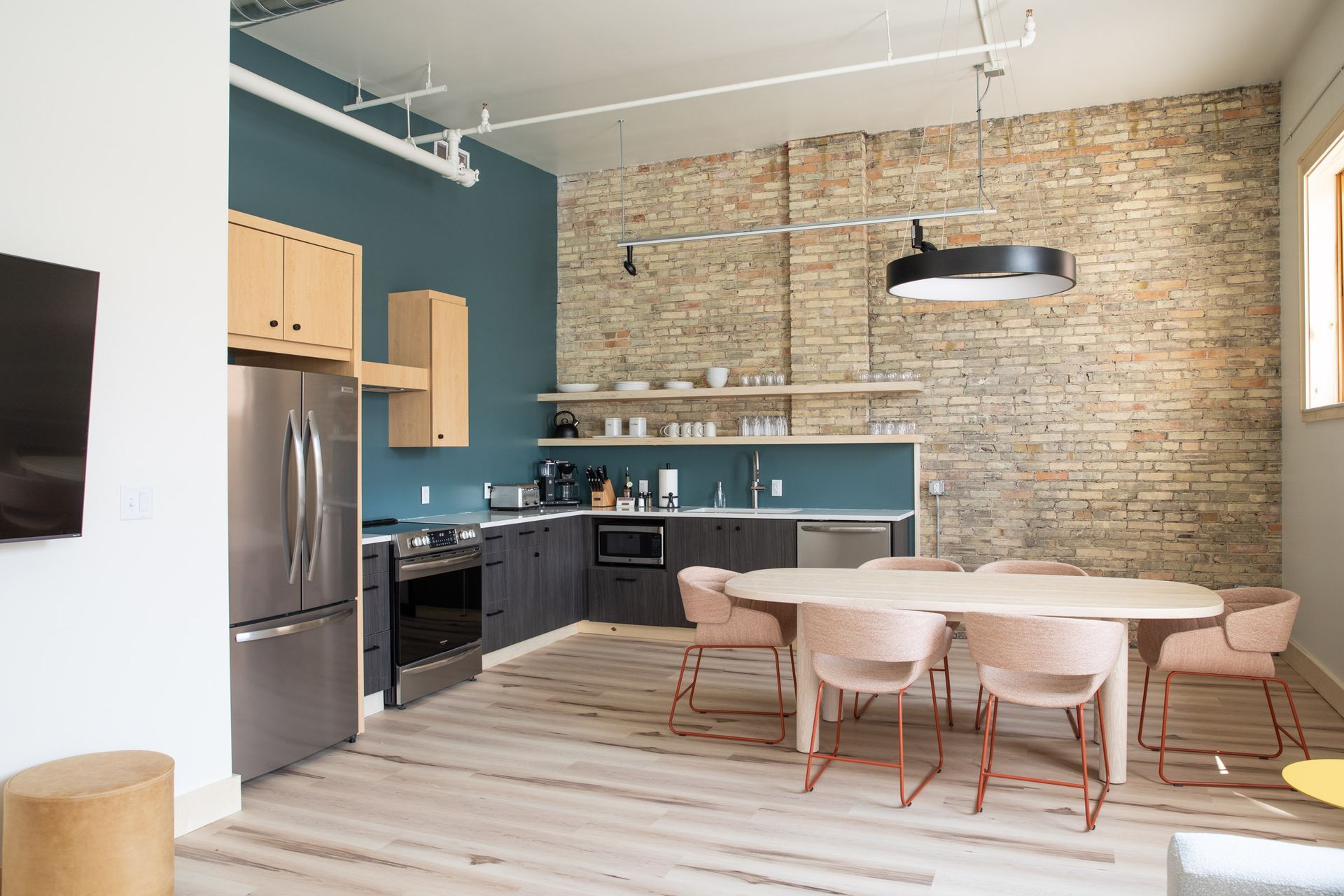 A kitchen with a table and chairs and a brick wall.