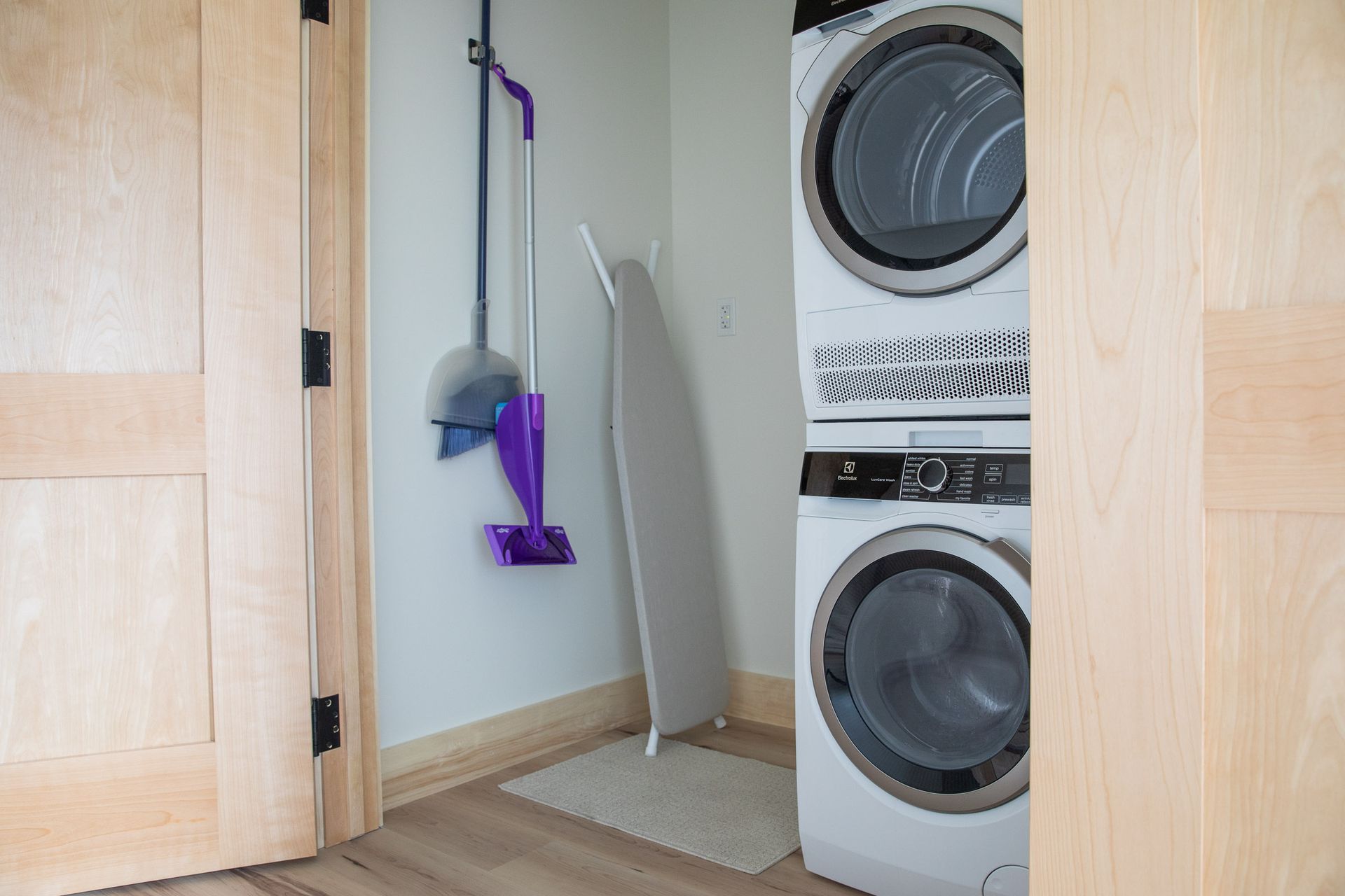 A washer and dryer are stacked on top of each other in a laundry room.