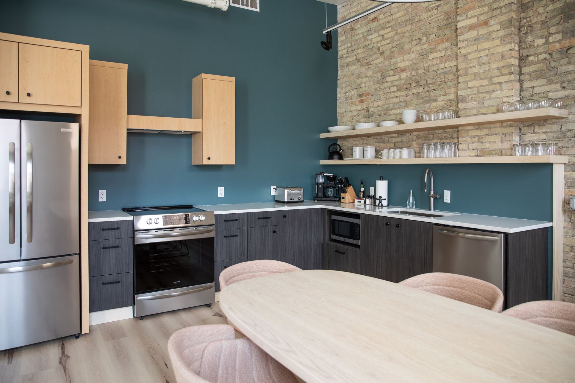 A kitchen with a table and chairs and a refrigerator.