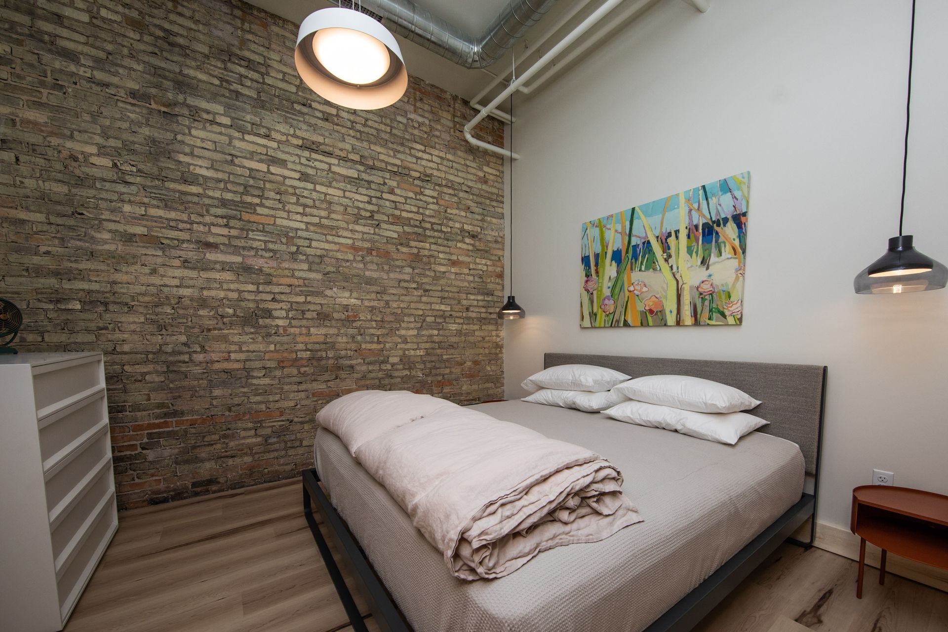 A bedroom with a bed and a painting on the wall