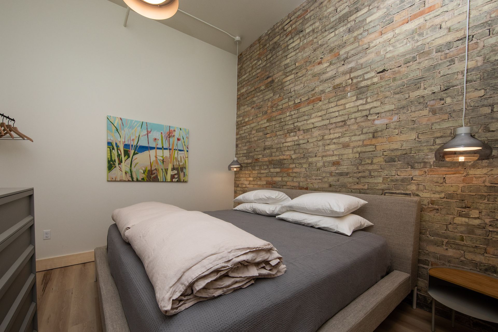 A bedroom with a bed and a painting on the wall.