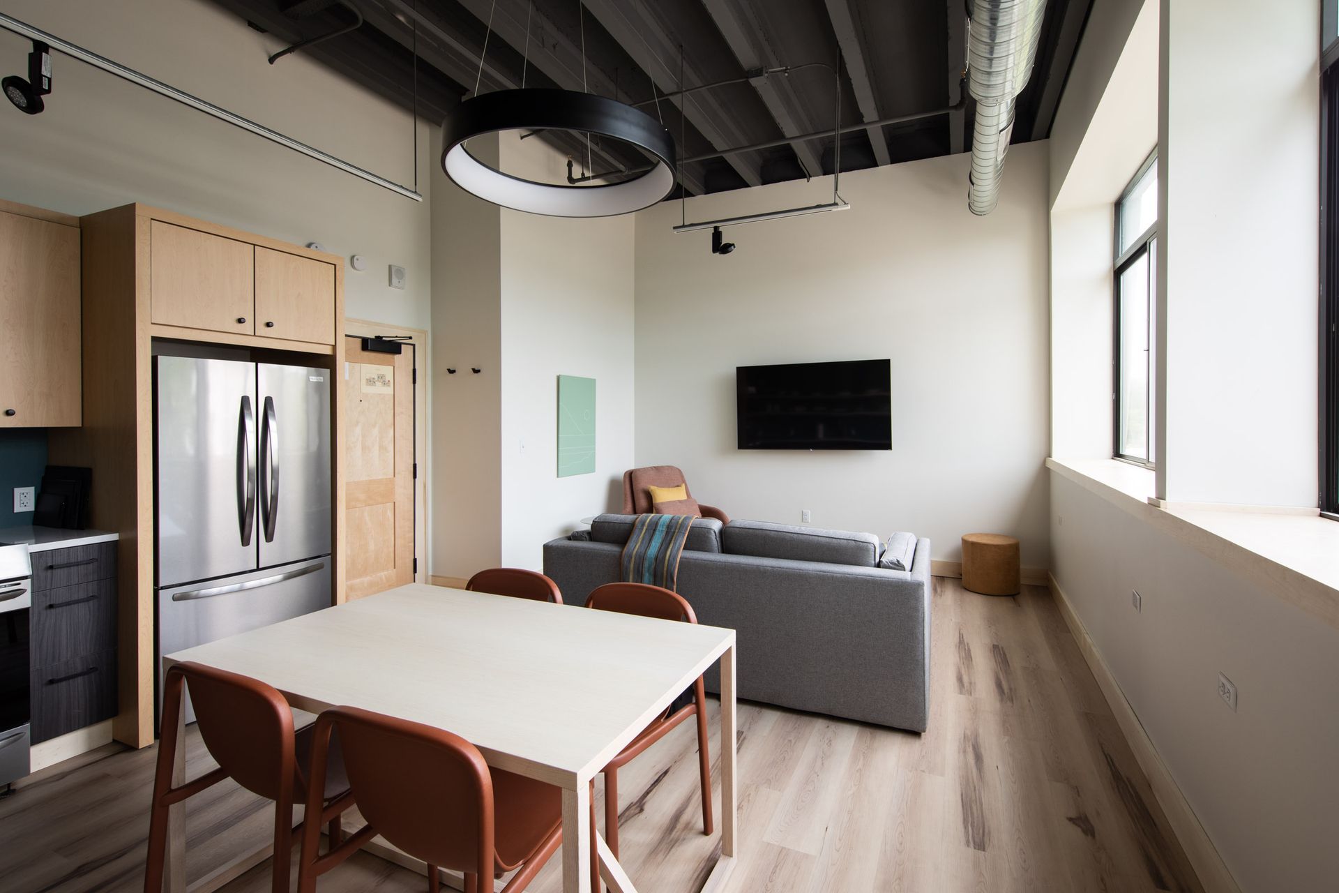 A living room with a table and chairs and a refrigerator.