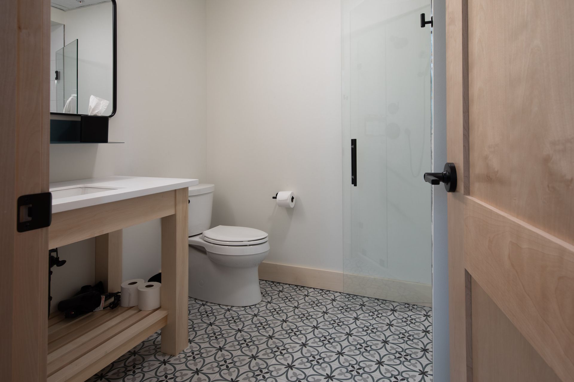 A bathroom with a toilet , sink and shower.