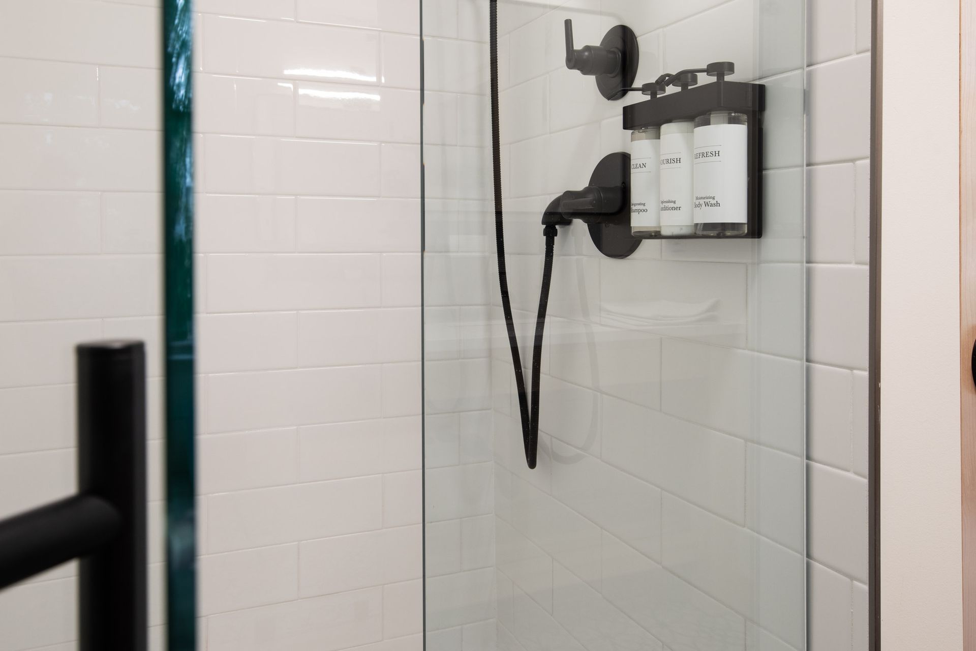 A bathroom with a shower stall and a hair dryer.