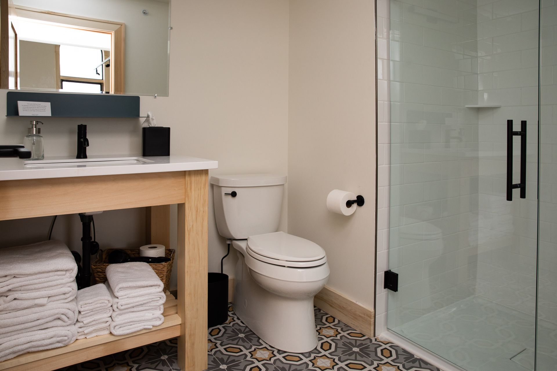 A bathroom with a toilet , sink and shower.