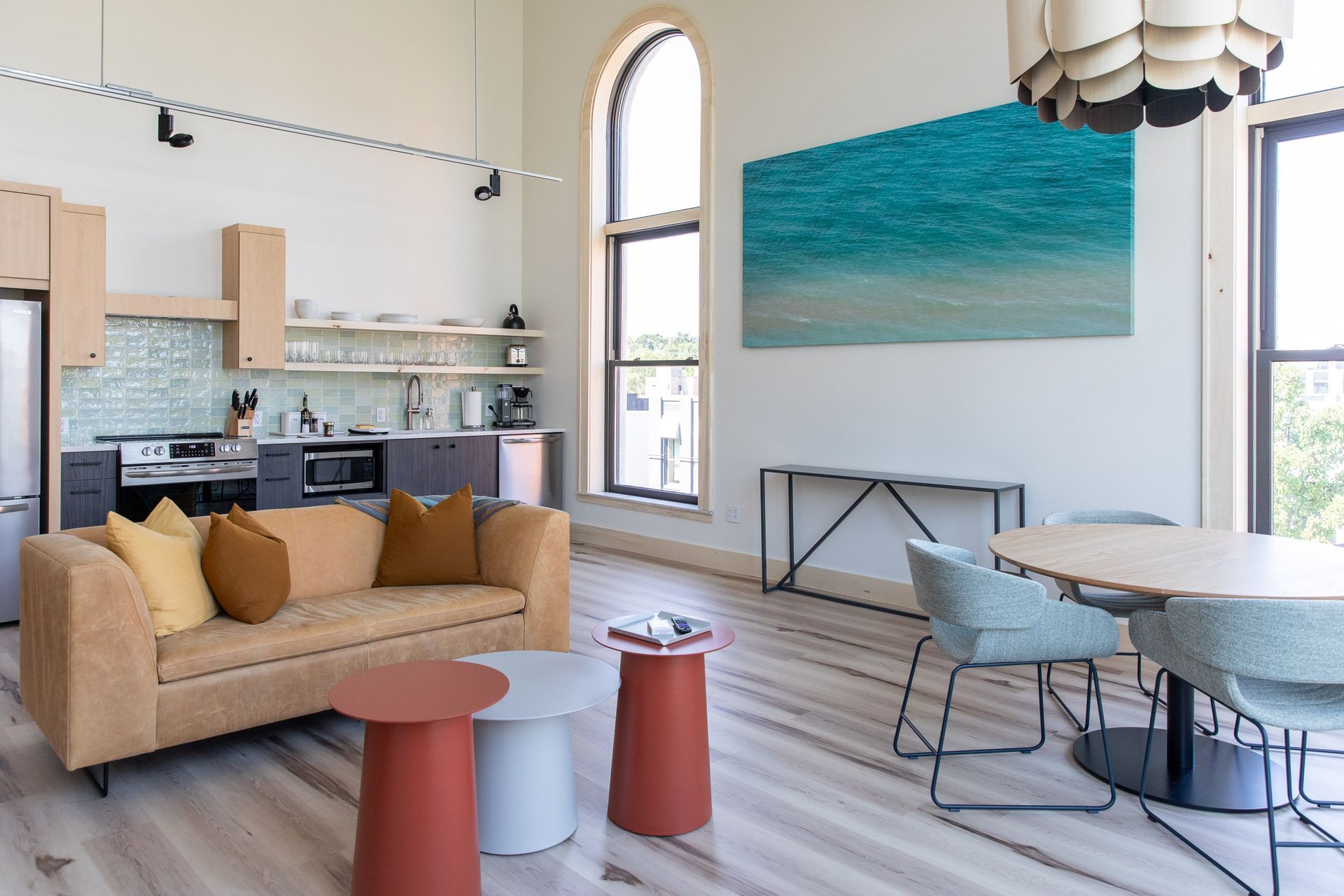 A living room with a couch , table , chairs and a kitchen.